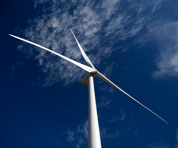 A single wind turbine with a deep blue sky background A single wind turbine with a deep blue sky background
