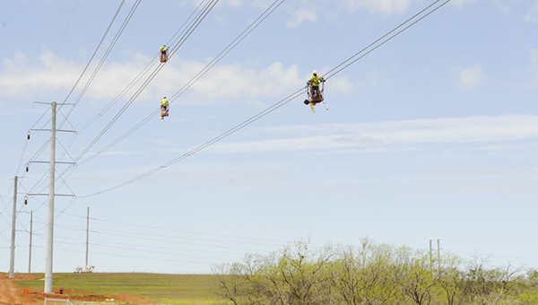 NextEra workers working on transmission lines air